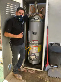 Victor giving a thumbs up beside a newly installed A.O. Smith tank water heater
